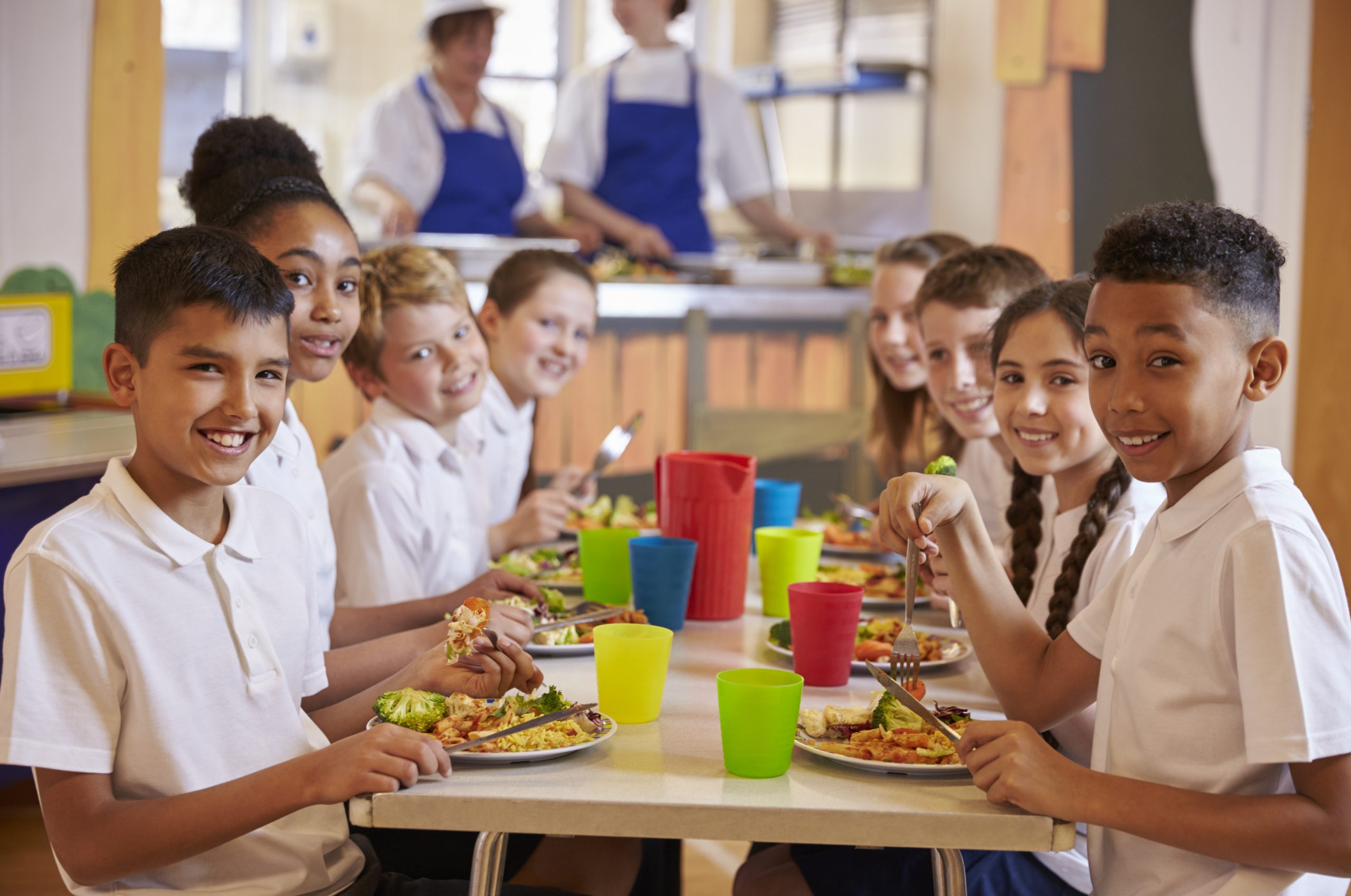 Photo d'enfants en train de manger autour d'une table dans une cantine scolaire